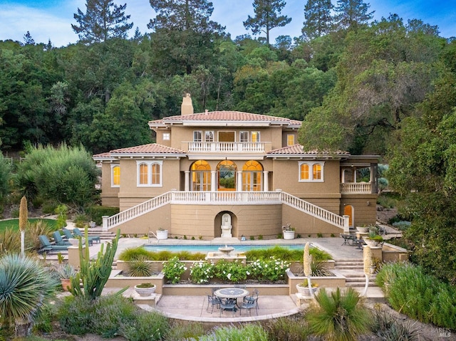 back of property with a patio area and a balcony