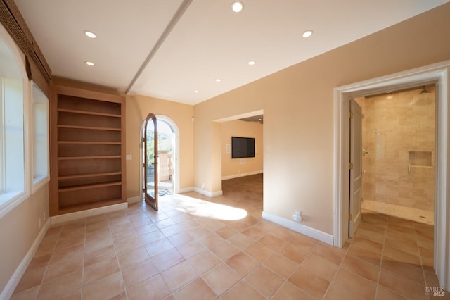 tiled spare room with built in shelves