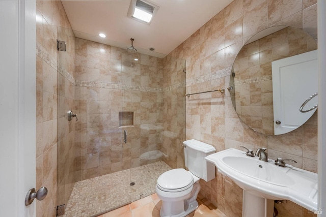 bathroom featuring sink, toilet, tile walls, and an enclosed shower