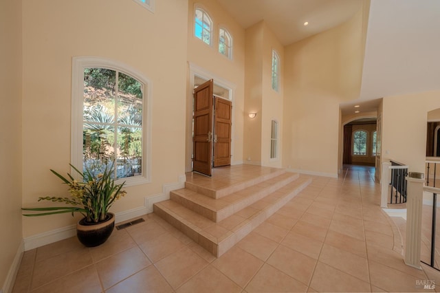 foyer with a high ceiling and light tile patterned floors