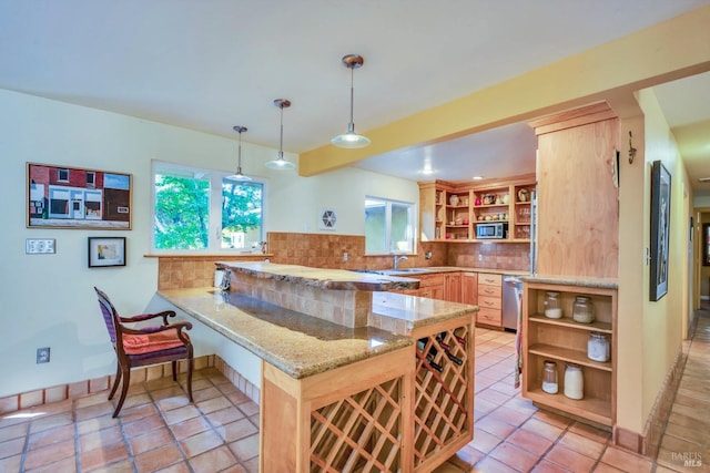 kitchen featuring pendant lighting, light stone countertops, appliances with stainless steel finishes, tasteful backsplash, and kitchen peninsula