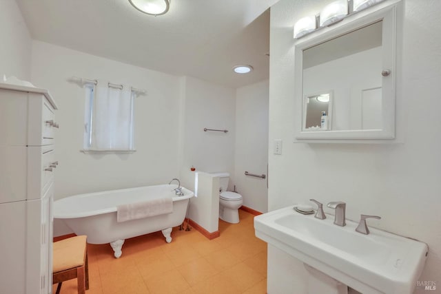 bathroom with toilet, a bathtub, and sink