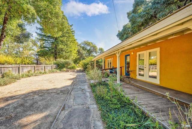 view of yard featuring a wooden deck and french doors