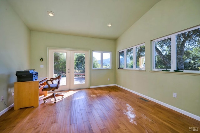 unfurnished office with light wood-type flooring, lofted ceiling, and french doors