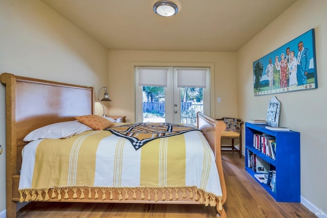 bedroom featuring french doors, access to outside, and hardwood / wood-style flooring