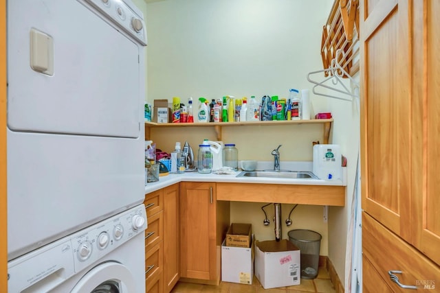 laundry room featuring cabinets, sink, and stacked washing maching and dryer