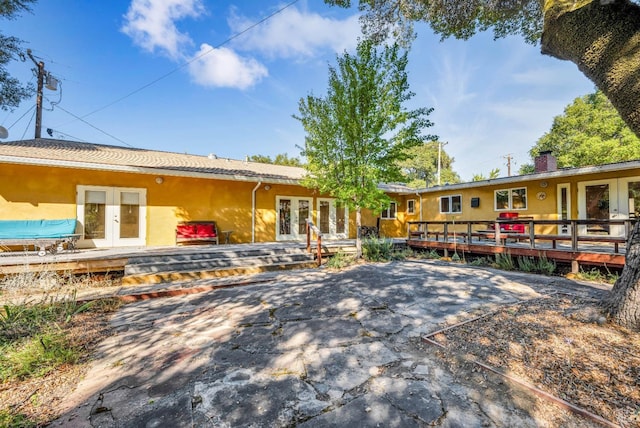 exterior space featuring a patio area, a wooden deck, and french doors