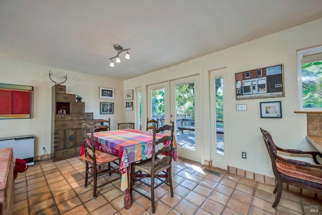 dining space with french doors and light tile patterned flooring