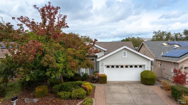 view of front of property featuring solar panels and a garage