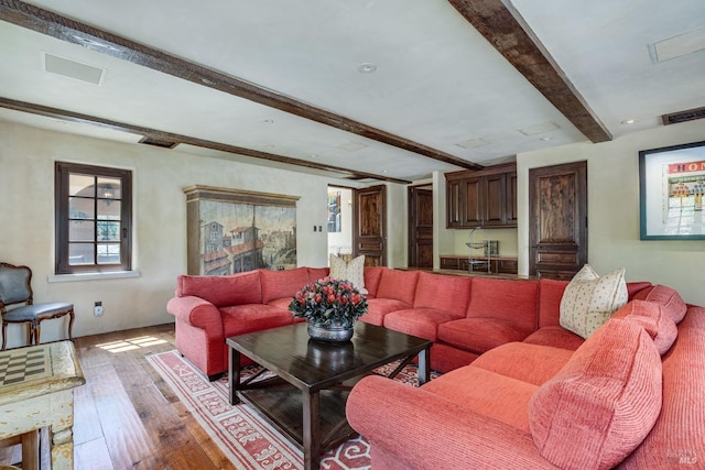 living room with light hardwood / wood-style floors and beamed ceiling