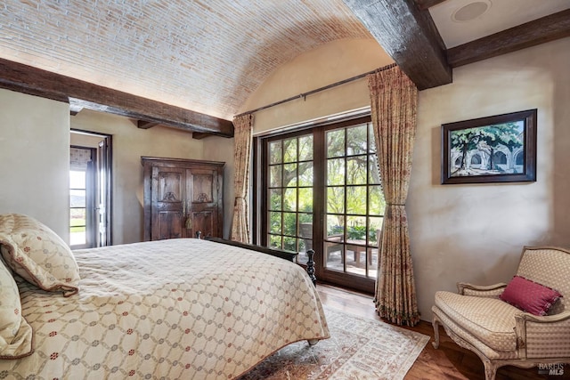 bedroom with light hardwood / wood-style floors, multiple windows, and beam ceiling