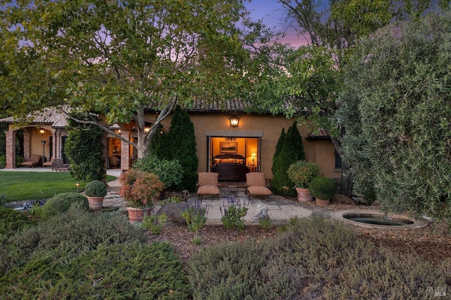 mediterranean / spanish-style house with a patio and a yard