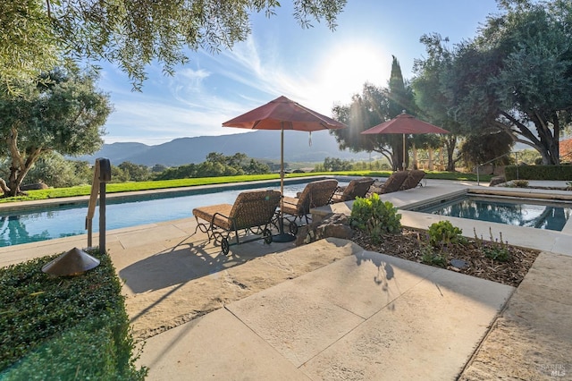 view of swimming pool with a patio area and a mountain view