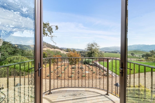 balcony featuring a rural view and a mountain view