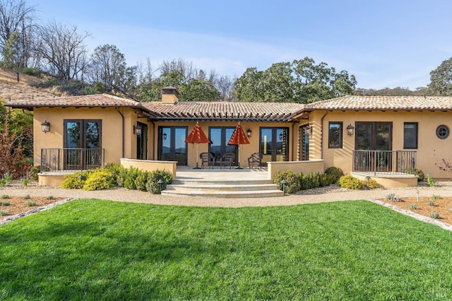 back of house featuring a patio and a lawn