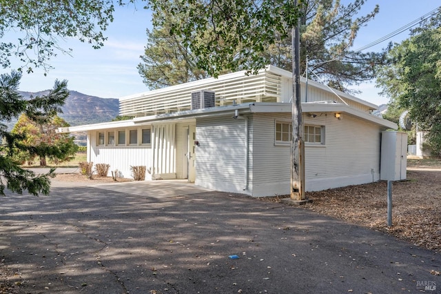 back of property with cooling unit and a mountain view