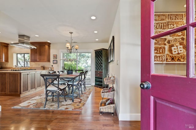 dining space with a chandelier, wood-type flooring, and plenty of natural light