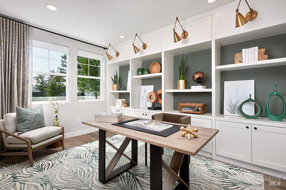 office space with light wood-type flooring and built in shelves