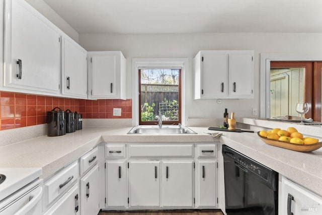kitchen with white cabinets, a sink, black dishwasher, and tasteful backsplash
