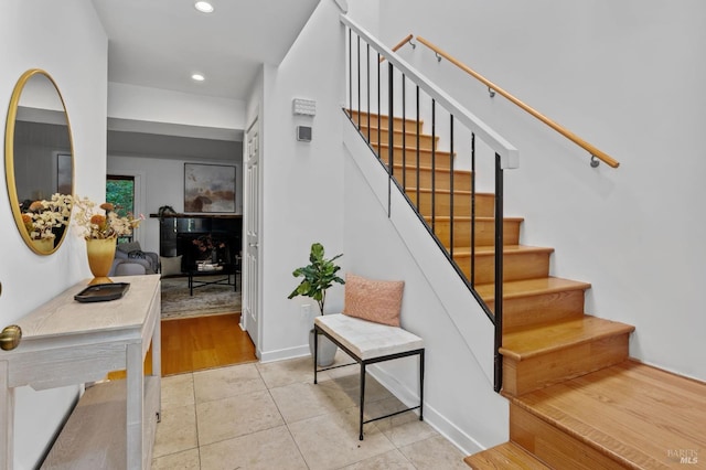 stairway featuring tile patterned flooring and recessed lighting