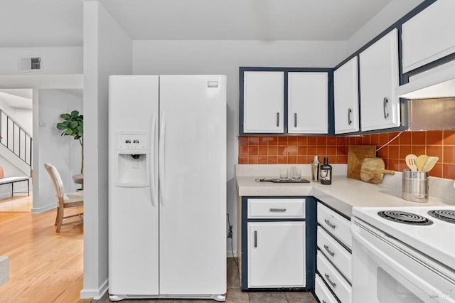 kitchen featuring light hardwood / wood-style flooring, white cabinets, backsplash, and white appliances