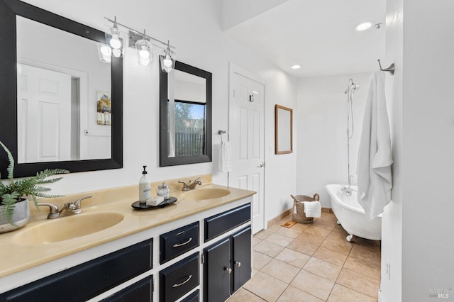 bathroom featuring double vanity, a sink, tile patterned flooring, and a freestanding bath