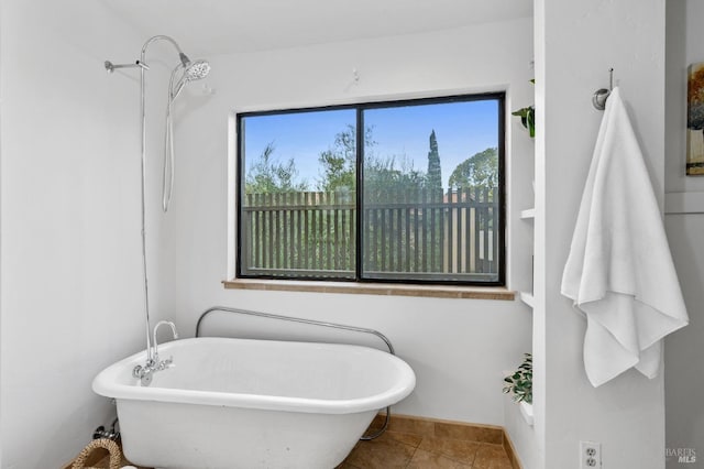 bathroom featuring tile patterned floors and a freestanding tub