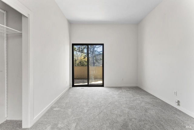 unfurnished bedroom featuring carpet flooring, baseboards, and access to outside