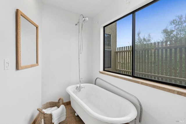 bathroom with a healthy amount of sunlight, tile patterned flooring, and a bathing tub