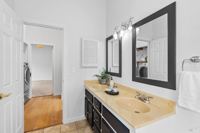 bathroom featuring washer / dryer, vanity, and tile patterned flooring