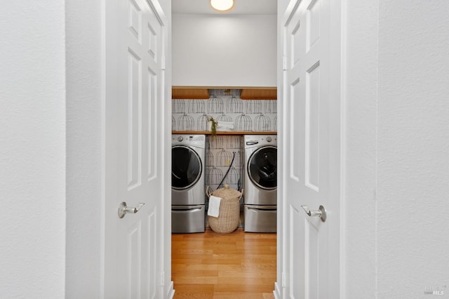laundry room with light wood-style floors and washer and dryer