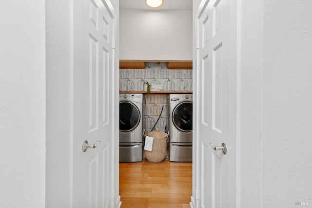 laundry room with wood-type flooring and washing machine and dryer