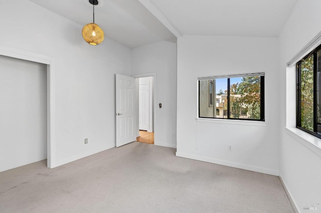 unfurnished bedroom featuring vaulted ceiling and light colored carpet