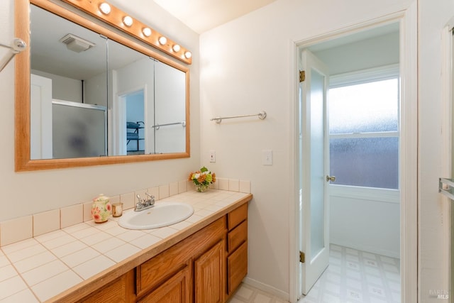 bathroom featuring vanity and a shower with shower door