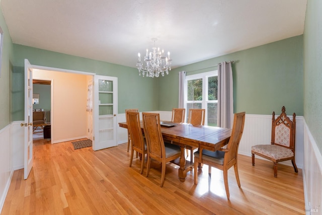 dining area featuring light hardwood / wood-style floors and a notable chandelier