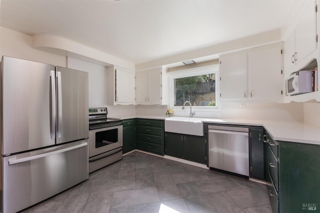 kitchen with appliances with stainless steel finishes, sink, and white cabinets