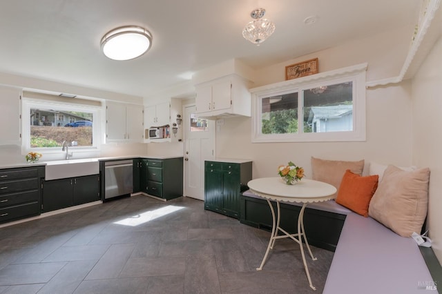 kitchen featuring dishwasher, white cabinets, sink, and breakfast area