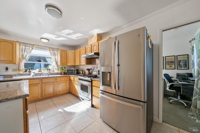 kitchen with stainless steel appliances, light stone countertops, light brown cabinetry, and light tile patterned flooring