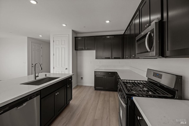 kitchen with sink, stainless steel appliances, and light wood-type flooring