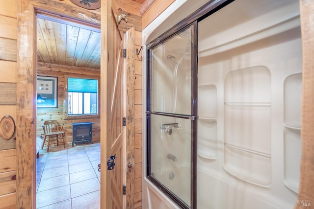 bathroom featuring wood ceiling, bath / shower combo with glass door, wood walls, a wood stove, and tile patterned floors