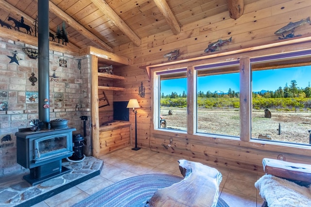 tiled living room featuring wood walls, lofted ceiling with beams, a wood stove, and wooden ceiling