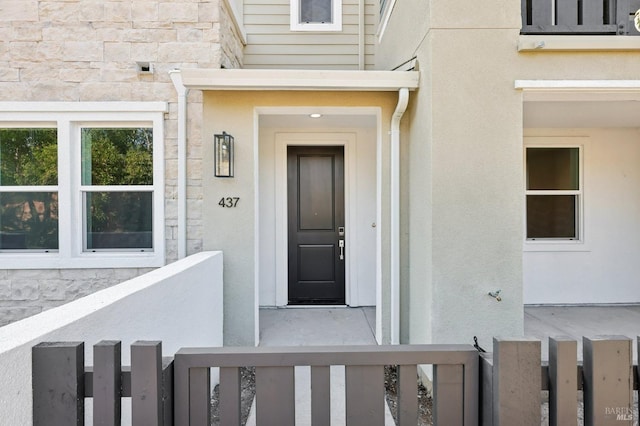 property entrance with stone siding and stucco siding