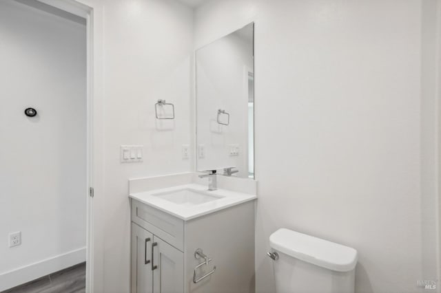 bathroom with vanity, toilet, and wood-type flooring