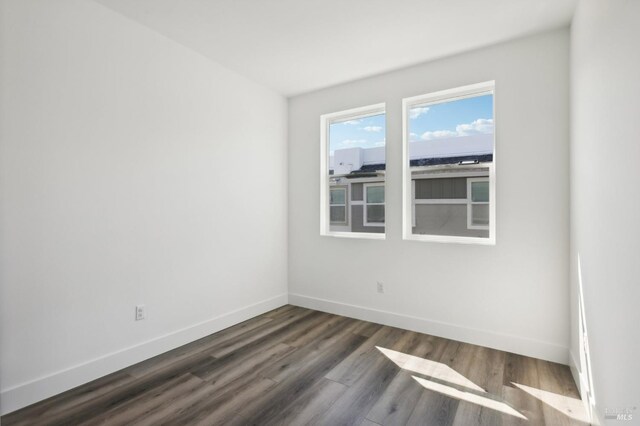 spare room featuring dark wood-type flooring