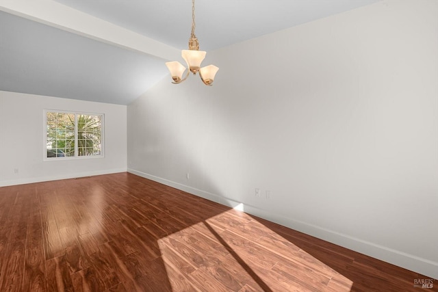 empty room featuring an inviting chandelier, lofted ceiling, and hardwood / wood-style floors