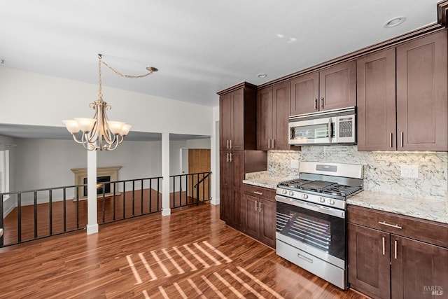 kitchen featuring dark hardwood / wood-style flooring, light stone countertops, appliances with stainless steel finishes, and dark brown cabinets