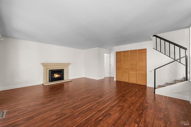 unfurnished living room with dark wood-type flooring