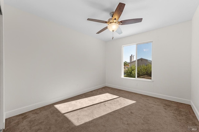 unfurnished room featuring dark colored carpet and ceiling fan