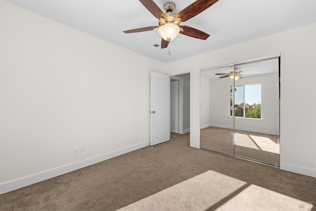 unfurnished bedroom with ceiling fan, carpet flooring, and a closet