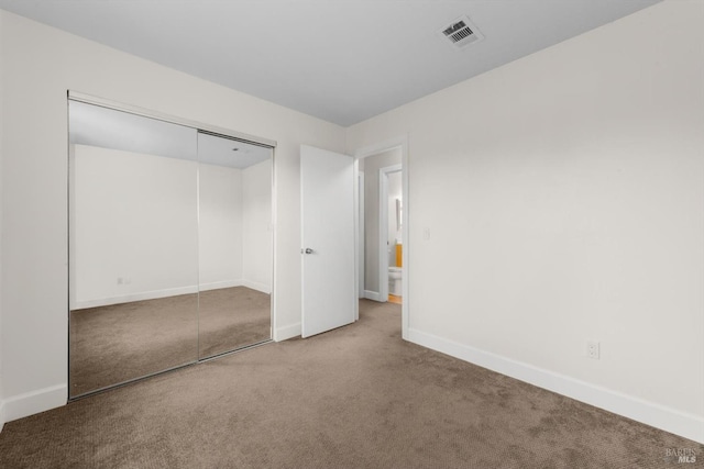 unfurnished bedroom with carpet floors and a closet